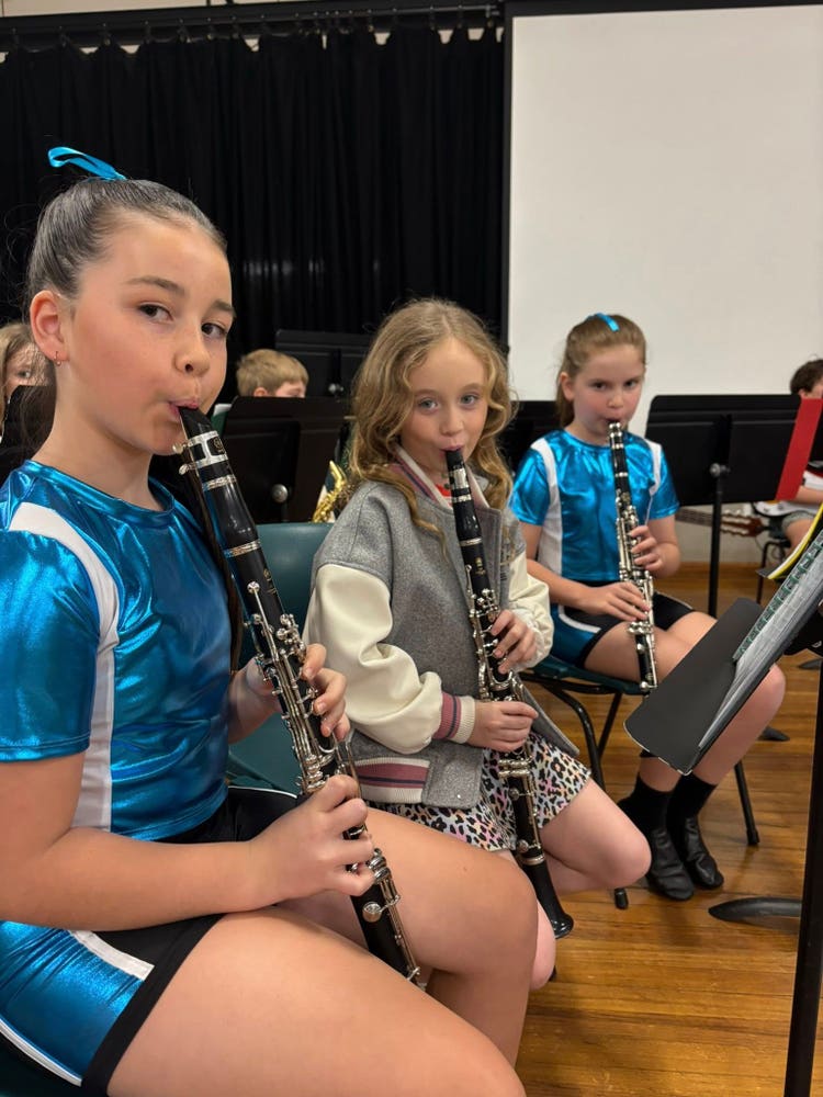 Three students playing clarinet in the band